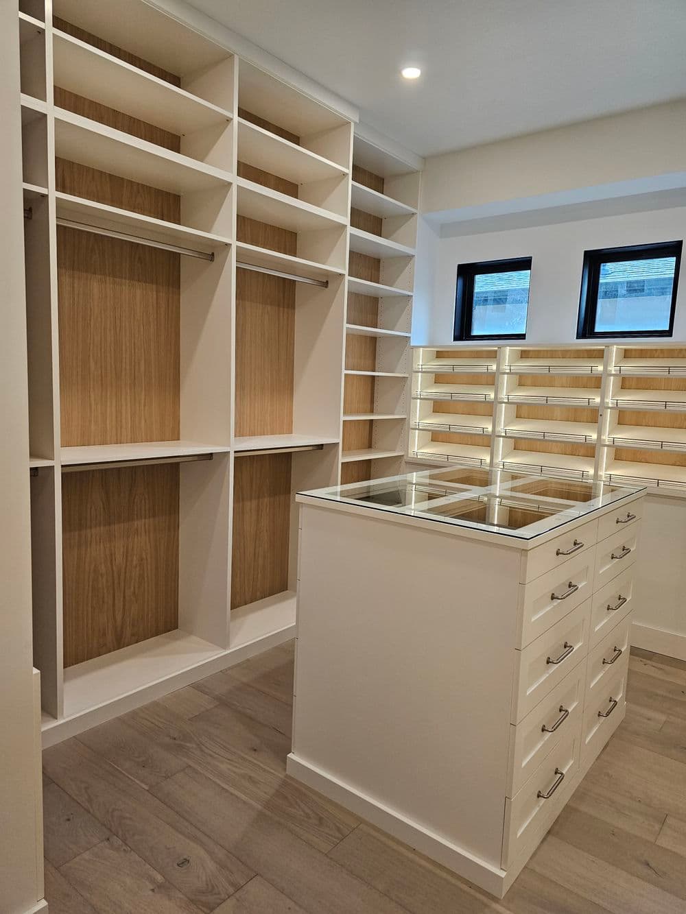 Spacious modern closet design with open shelves and a central drawer island for organization.