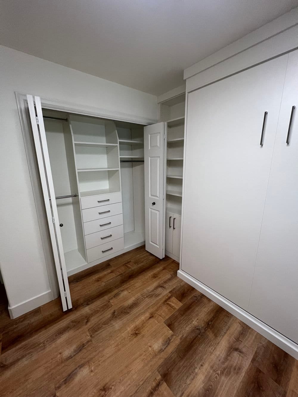 Modern closet organization with shelving and drawers, featuring a sleek white design.
