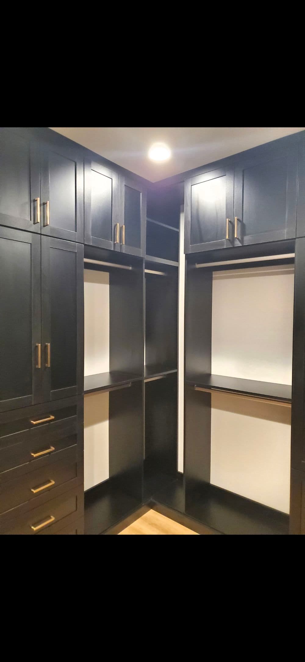 Modern black custom closet with open shelving and stylish hardware. Organized and spacious storage.