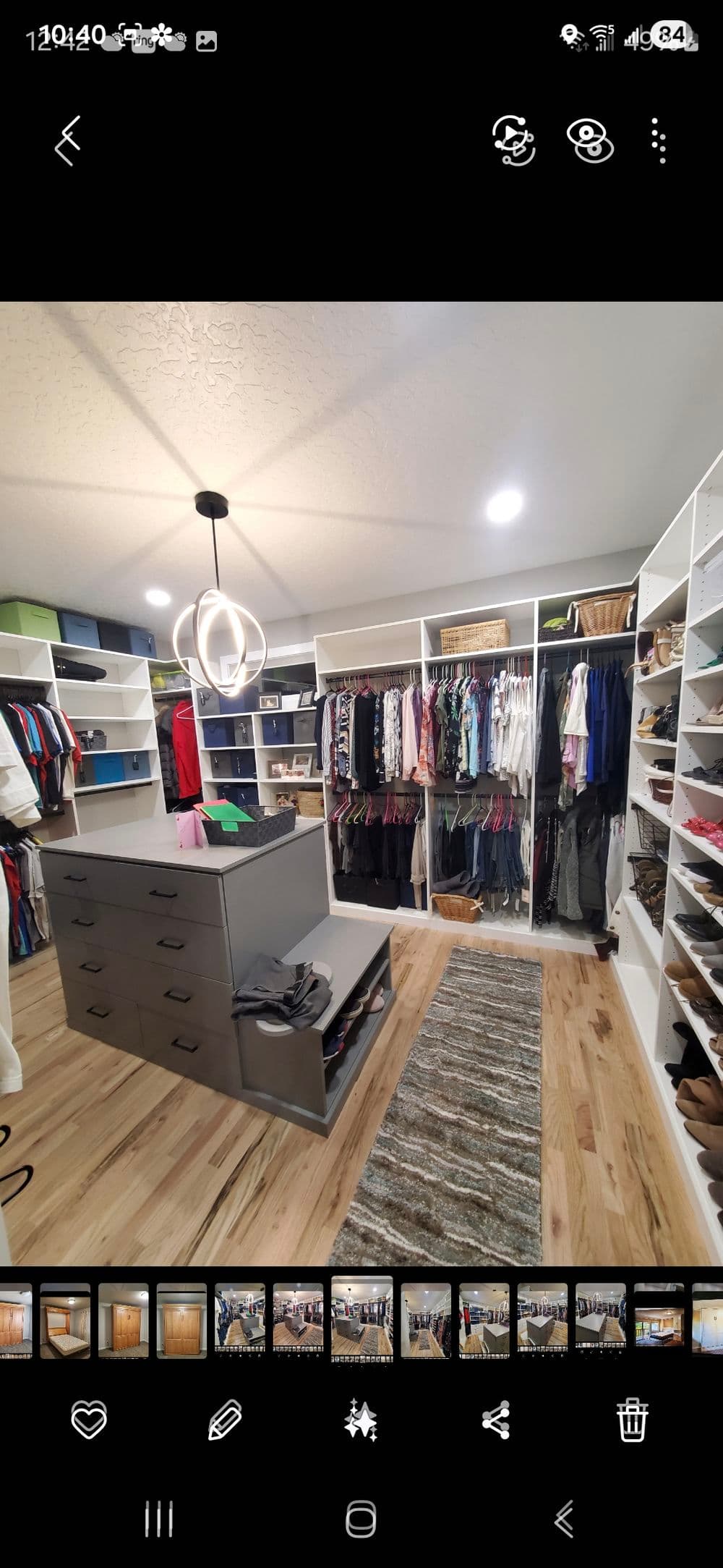 Modern walk-in closet featuring organized shelves, drawers, and stylish lighting.
