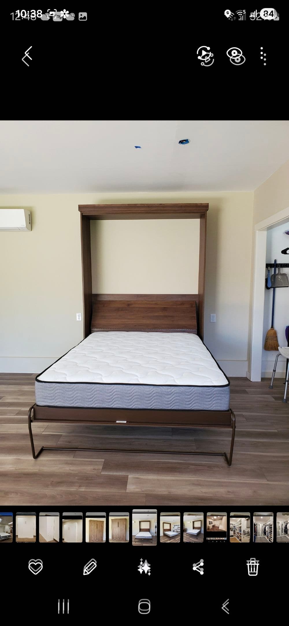 Modern wooden Murphy bed with mattress folded down in stylish room interior.