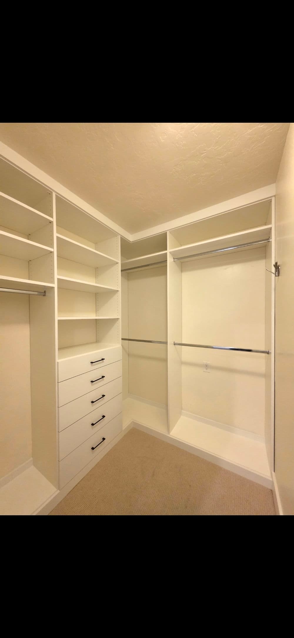 Spacious modern walk-in closet with shelves and organized drawers.