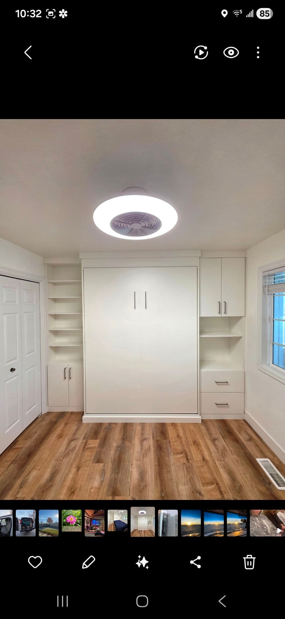 Modern minimalist room with a white fold-out bed, shelves, and wooden flooring.